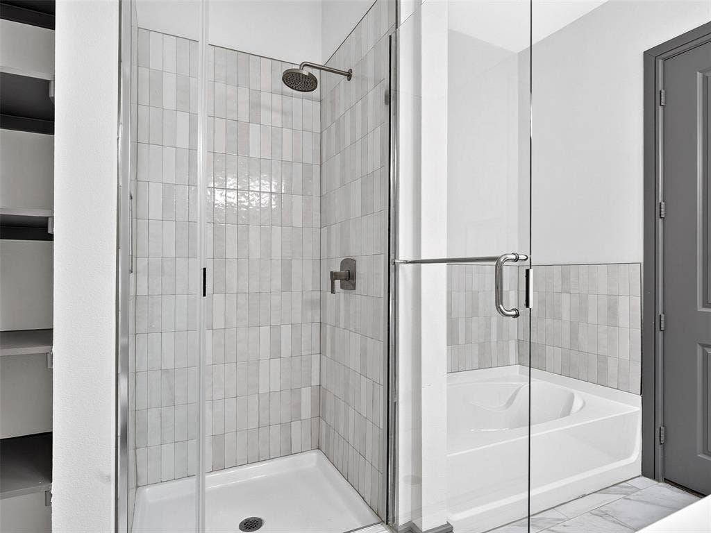 2700 Old Denton Road, #2212, Carrollton, TX 75007 Glass-enclosed shower with a rainfall showerhead, and vertical tile surround