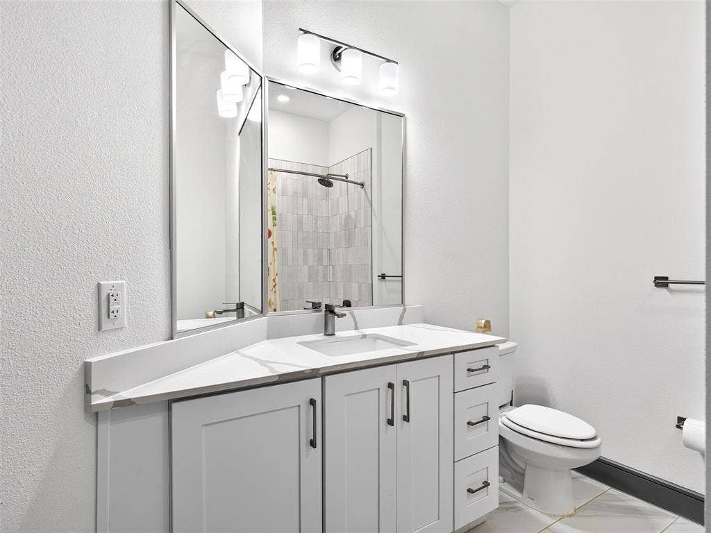 2700 Old Denton Road, #2212, Carrollton, TX 75007 White shaker-style vanity with matte black hardware, dual undermount sinks, and a light-toned countertop