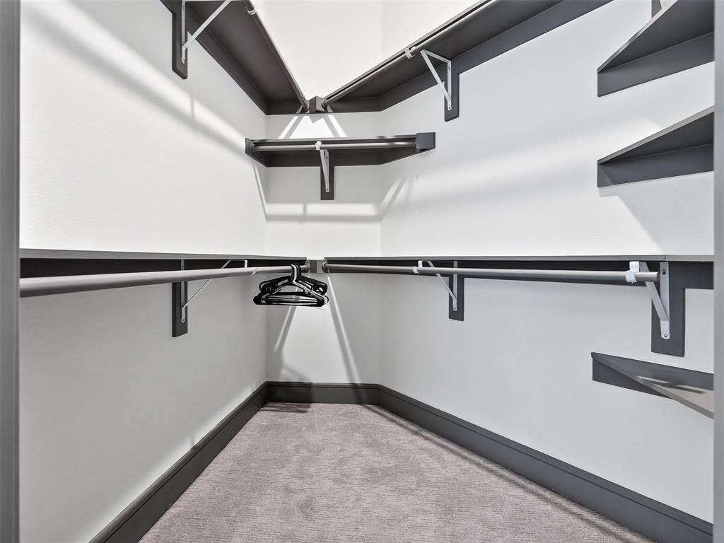 2700 Old Denton Road, #2212, Carrollton, TX 75007 Walk-in closet featuring built-in shelving, hanging rods, and grey carpeting