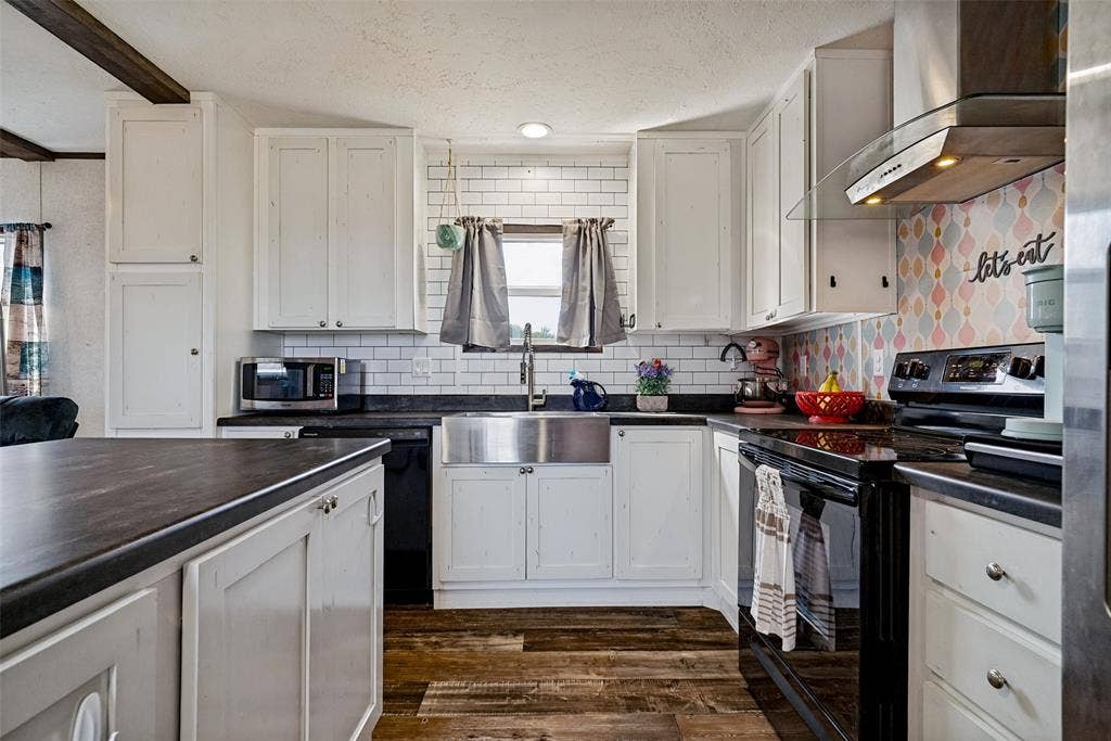 4415 Woodland Drive, Granbury, TX 76048 Kitchen featuring white cabinetry, dark countertops, a subway tile backsplash, a stainless steel apron sink, and wood-finish flooring