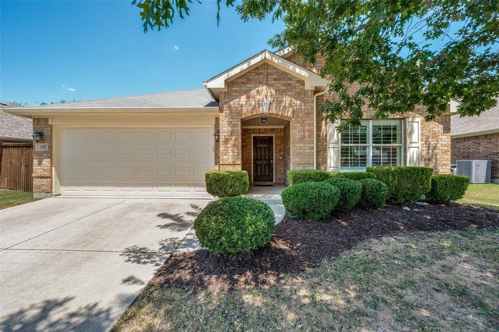 3707 Redwood Circle, Melissa, TX 75454 Brick exterior with an arched entryway and a two-car garage