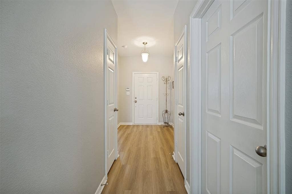 3707 Redwood Circle, Melissa, TX 75454 Entry hallway featuring wood-finish flooring, white paneled doors, and light gray wall paint