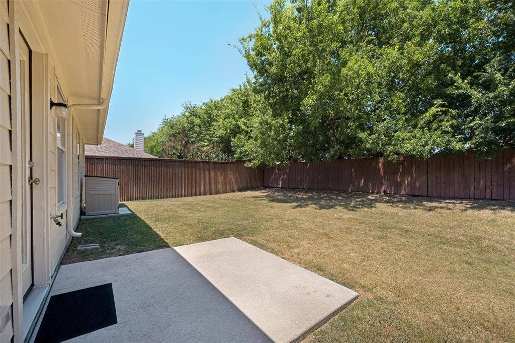 3707 Redwood Circle, Melissa, TX 75454 Expansive backyard with a concrete patio, wood privacy fencing, and mature trees