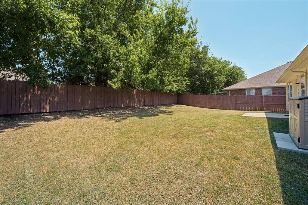 3707 Redwood Circle, Melissa, TX 75454 Expansive backyard with a full privacy fence, mature trees, and a concrete patio