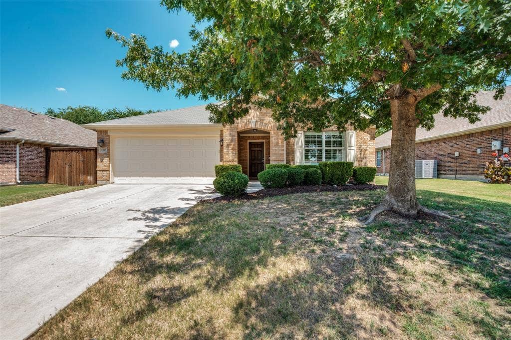 3707 Redwood Circle, Melissa, TX 75454 Brick facade with a prominent front door, attached garage, manicured shrubs, and a mature tree