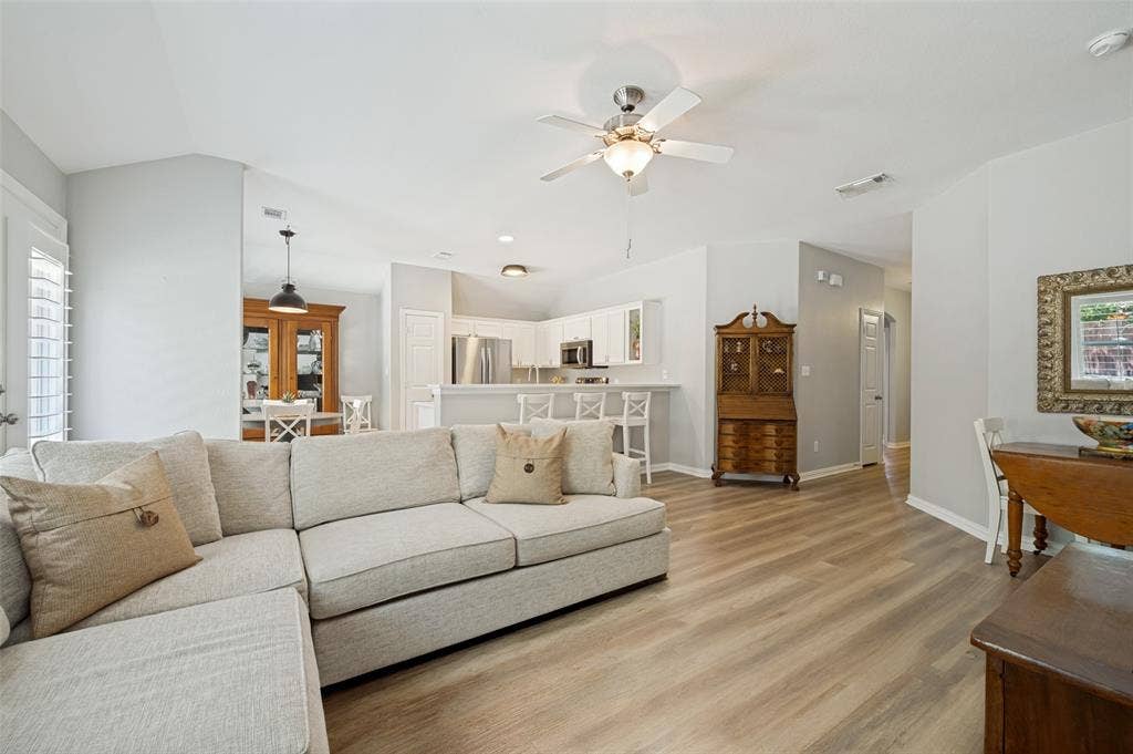 3707 Redwood Circle, Melissa, TX 75454 Open-concept living area featuring wood-finish flooring, vaulted ceilings, and a ceiling fan