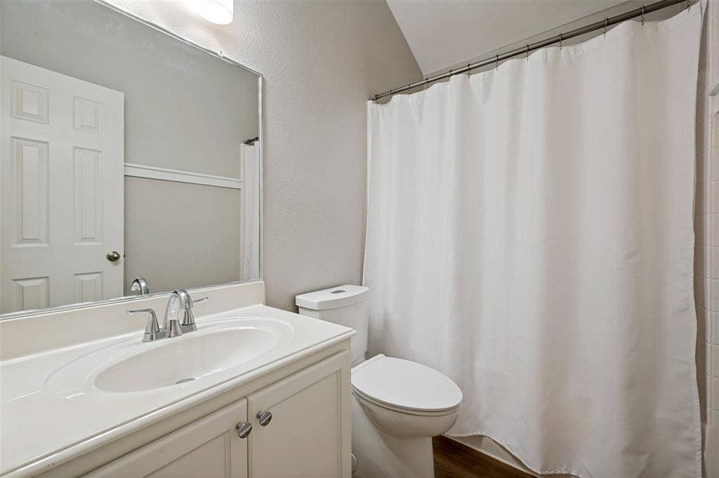 3707 Redwood Circle, Melissa, TX 75454 Vanity with an integrated sink and chrome faucet, white paneled door, and a toilet