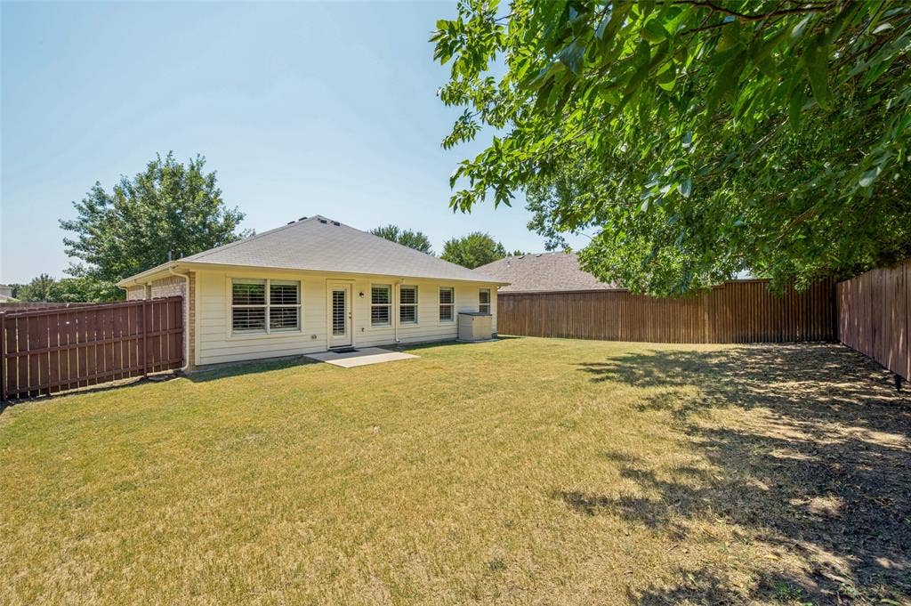 3707 Redwood Circle, Melissa, TX 75454 Expansive backyard featuring a concrete patio, wood fencing, and mature trees