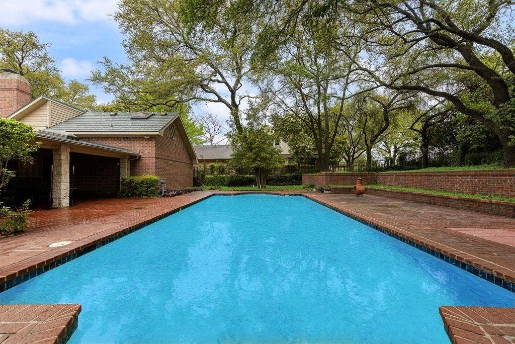 2 Eastshore Road, Heath, TX 75032 Elongated swimming pool surrounded by brick coping and a spacious brick patio
