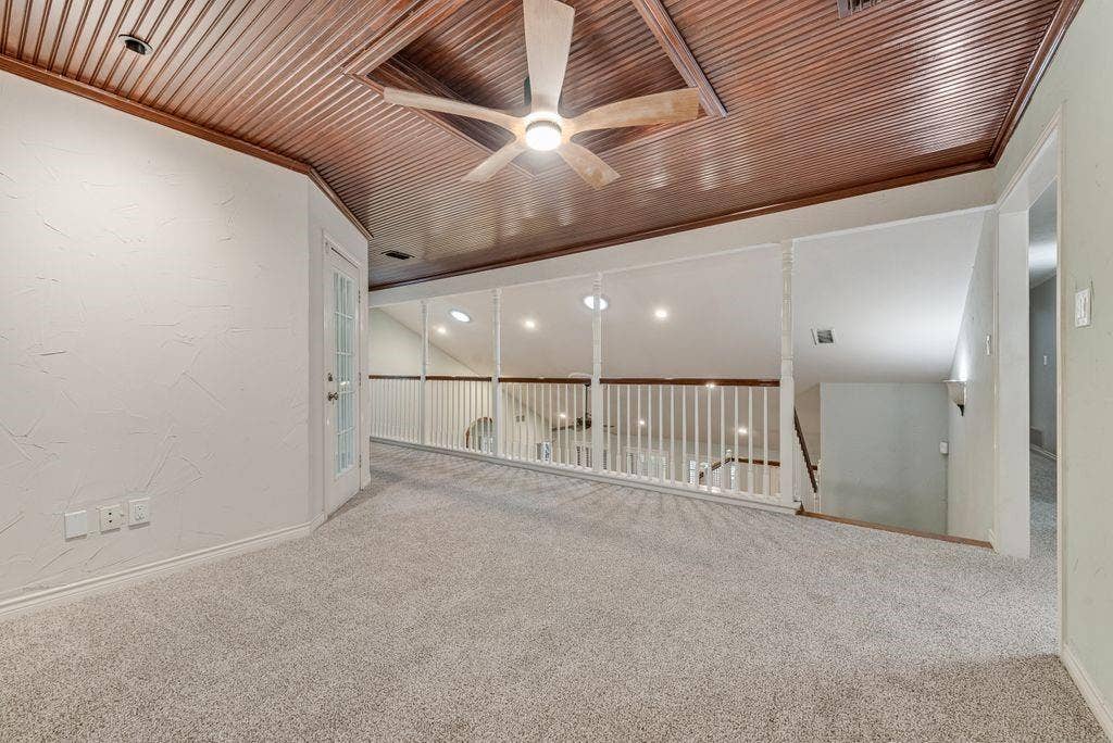 2 Eastshore Road, Heath, TX 75032 Loft area with wood-paneled ceiling, ceiling fan, carpet flooring, and white railing overlooking lower level