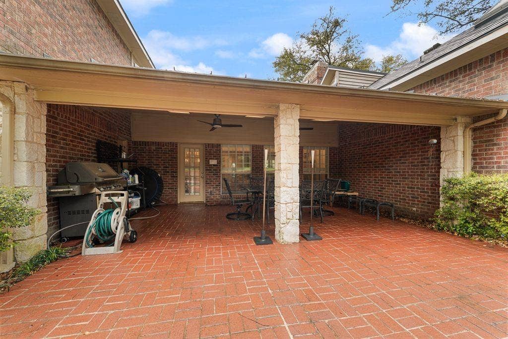 2 Eastshore Road, Heath, TX 75032 Covered patio featuring a brick paver floor, brick exterior walls, and stone-clad support columns