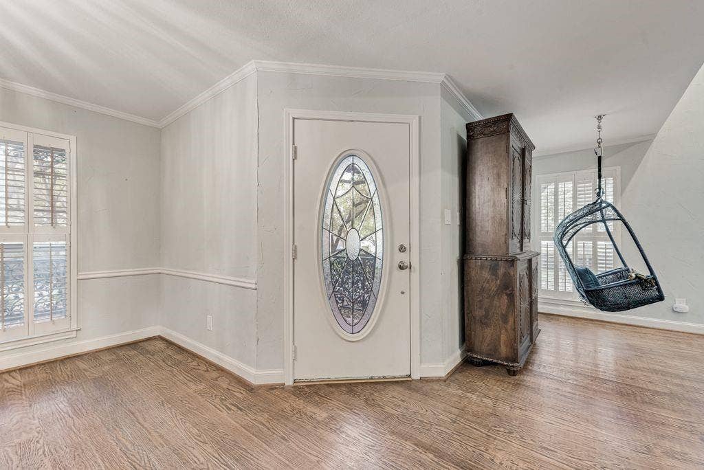 2 Eastshore Road, Heath, TX 75032 Entryway featuring wood-finish flooring, a front door with an oval stained-glass insert, and white plantation shutters