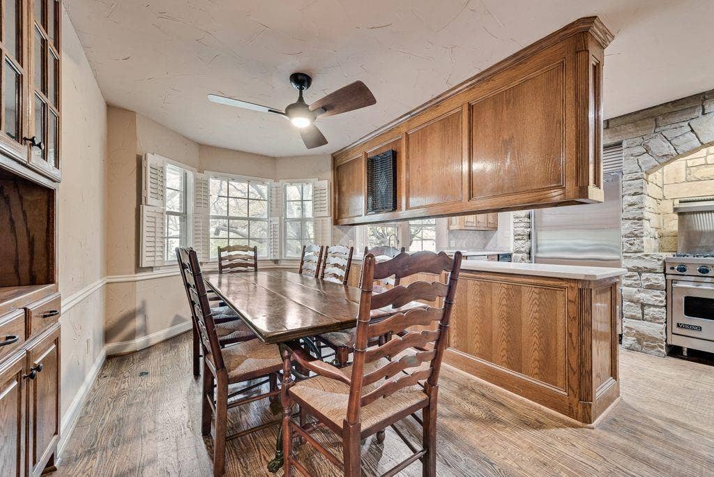 2 Eastshore Road, Heath, TX 75032 Wood-finish flooring, bay windows with plantation shutters, wood paneling, stone archway, and stainless steel range
