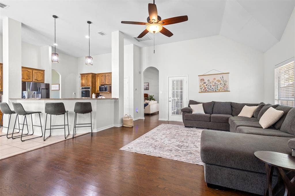 5413 Compassion Drive, Midlothian, TX 76065 Vaulted ceilings, wood-finish flooring, recessed lighting, ceiling fan, and a kitchen pass-through with pendant lighting