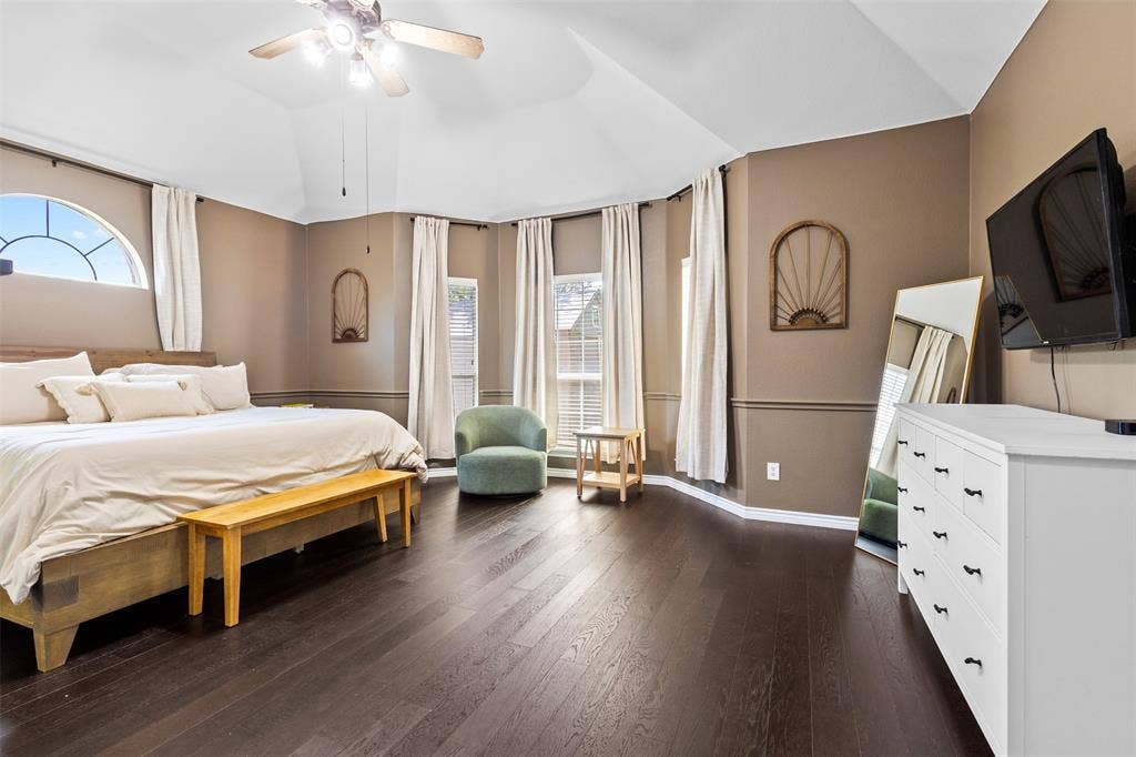 5413 Compassion Drive, Midlothian, TX 76065 Vaulted ceiling with a ceiling fan, dark wood-finish flooring, and multiple windows including an arched transom window