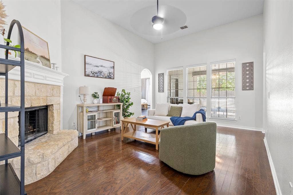 5413 Compassion Drive, Midlothian, TX 76065 Vaulted ceilings, a stone fireplace, wood-finish flooring, and expansive windows