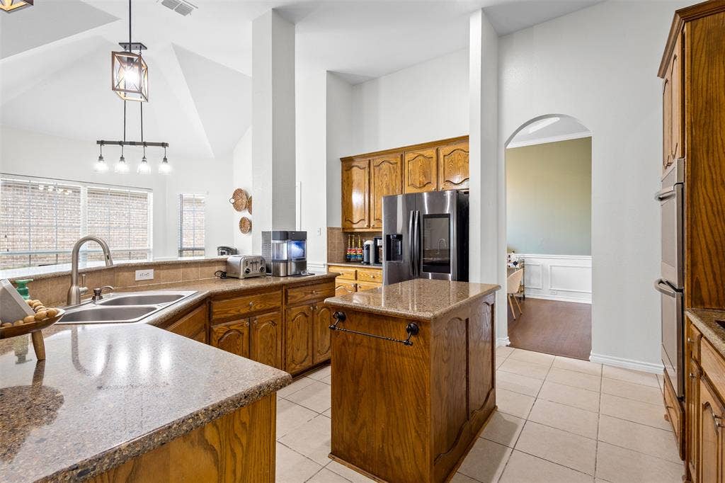 5413 Compassion Drive, Midlothian, TX 76065 Kitchen featuring wood cabinetry, granite countertops, stainless steel refrigerator, and ceramic tile flooring