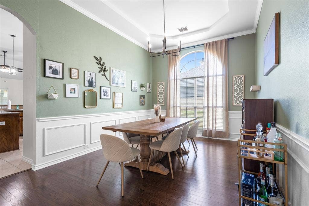 5413 Compassion Drive, Midlothian, TX 76065 Tray ceiling with crown molding, wainscoting, wood-finish flooring, and an arched window