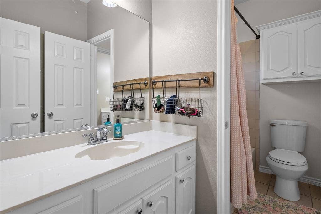 5413 Compassion Drive, Midlothian, TX 76065 White vanity with an integrated sink, polished chrome faucet, and a large wall-mounted mirror