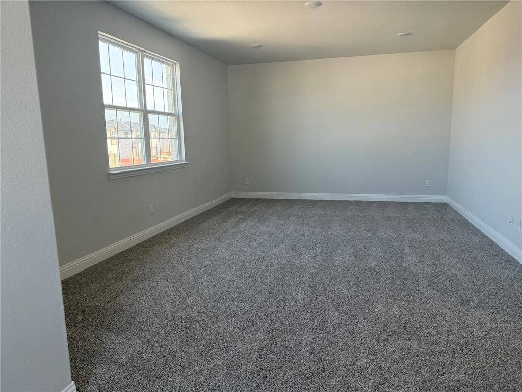 Recessed ceiling lighting, neutral gray wall paint, white trim, and gray carpet