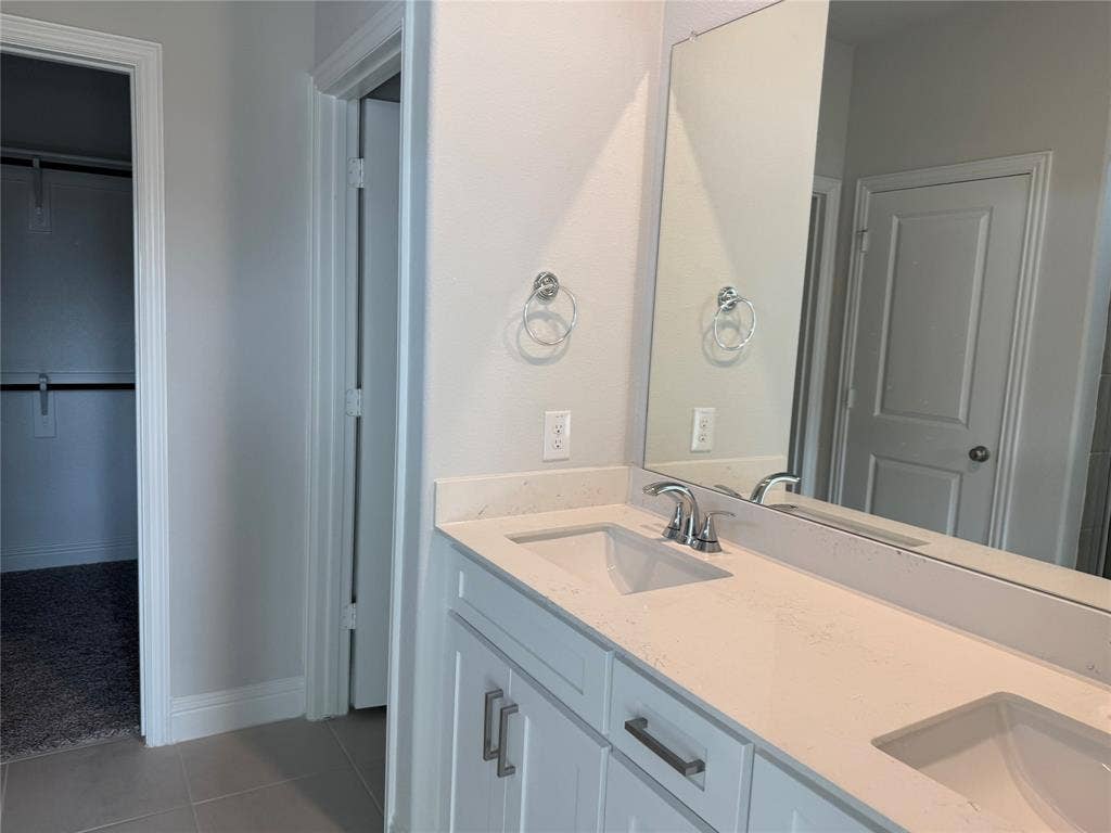 Dual vanity with undermount sinks, stone countertop, and chrome fixtures