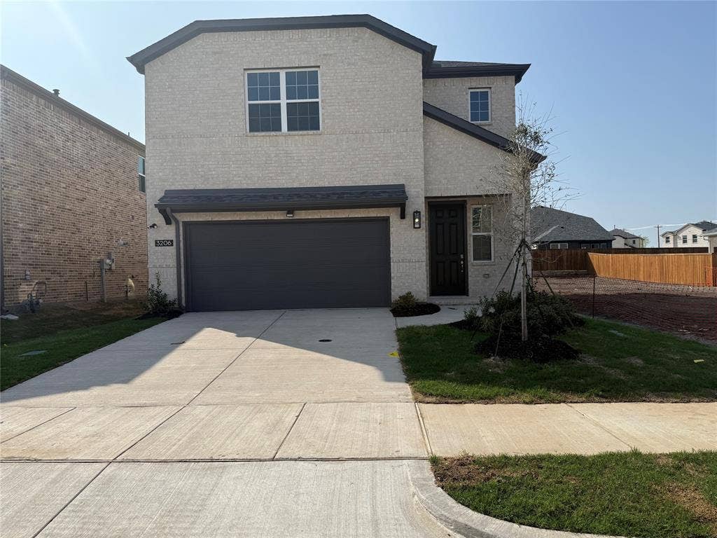 Two-story exterior featuring brick cladding and a dark gray garage door