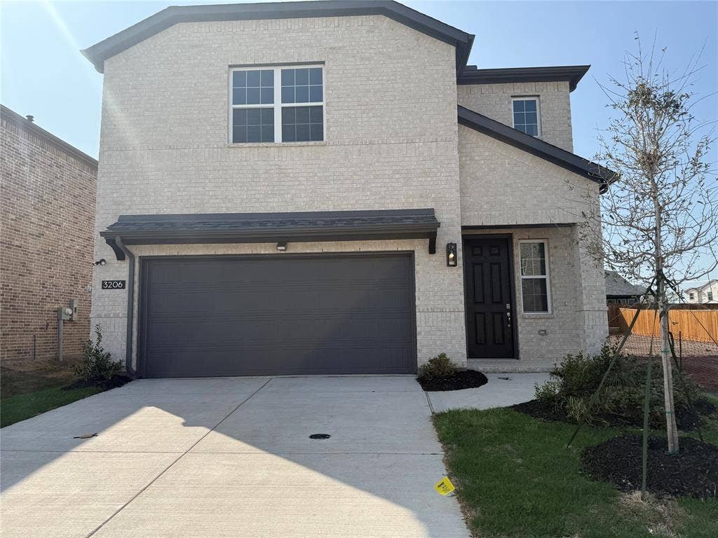 Brick exterior with dark trim and black garage door