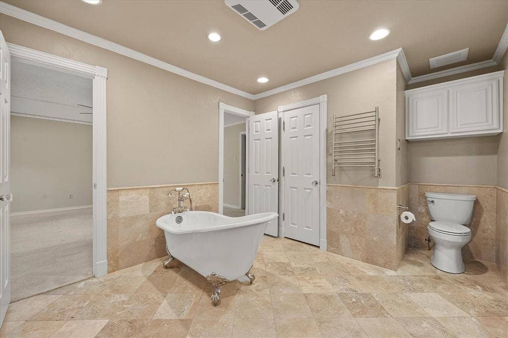 4001 Keele Drive, Garland, TX 75041 Over the toilet cabinets, heated towel bar, and closets on each side of this spa type bath.