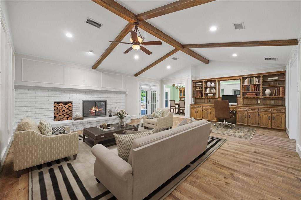 4001 Keele Drive, Garland, TX 75041 Virtually stated spacious family room featuring a dramatic vaulted ceiling with exposed beams, cozy fireplace, and beautiful built in cabinetry that contains storage and even a desk!