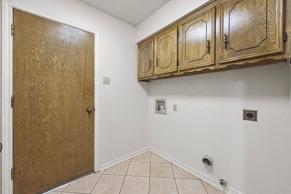 4001 Keele Drive, Garland, TX 75041 Laundry room with overhead cabinetry. Door leads to garage.