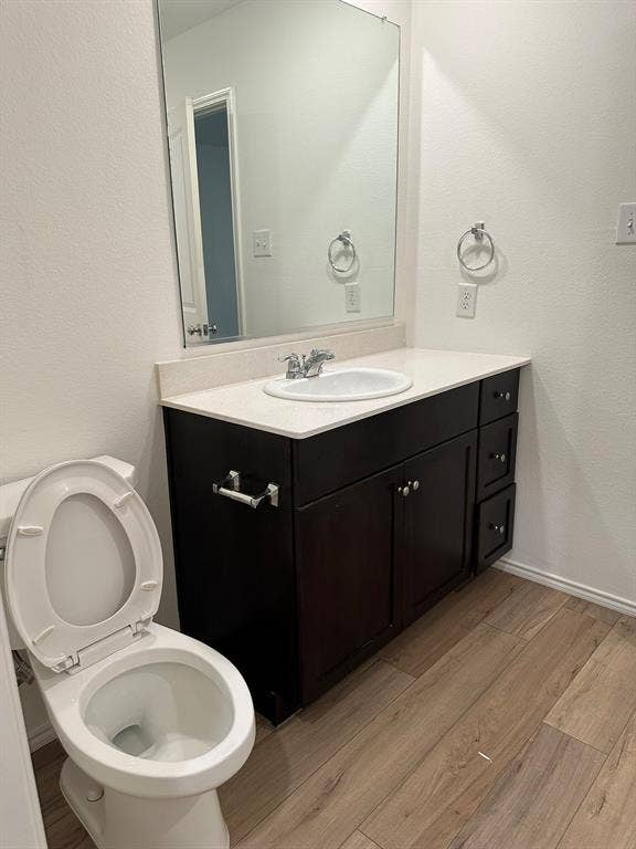 5705 Manarchos Lane, Forney, TX 75126 Bathroom with wood finished floors, vanity, and a textured wall