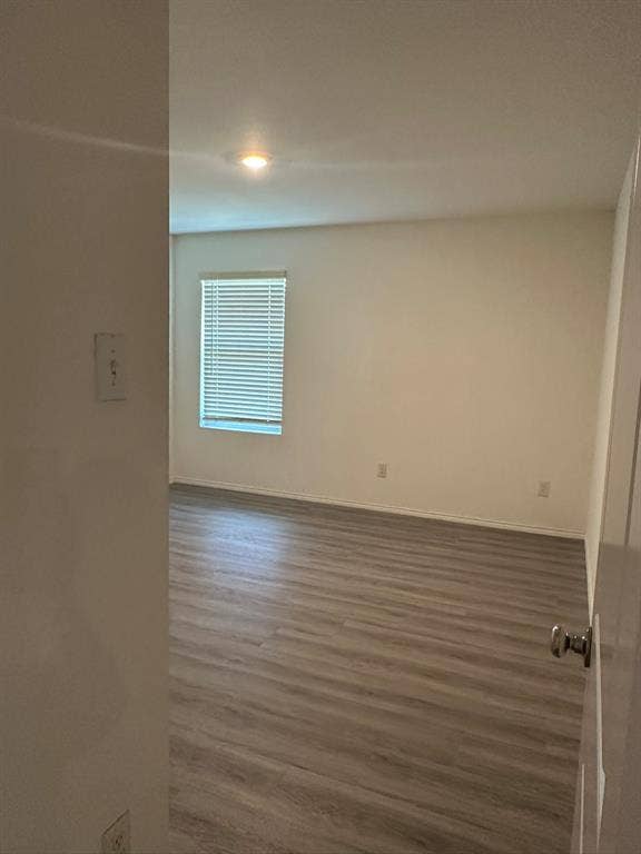 5705 Manarchos Lane, Forney, TX 75126 Empty room featuring wood finished floors and baseboards