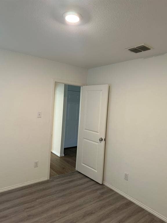 5705 Manarchos Lane, Forney, TX 75126 Empty room featuring wood finished floors and a textured ceiling