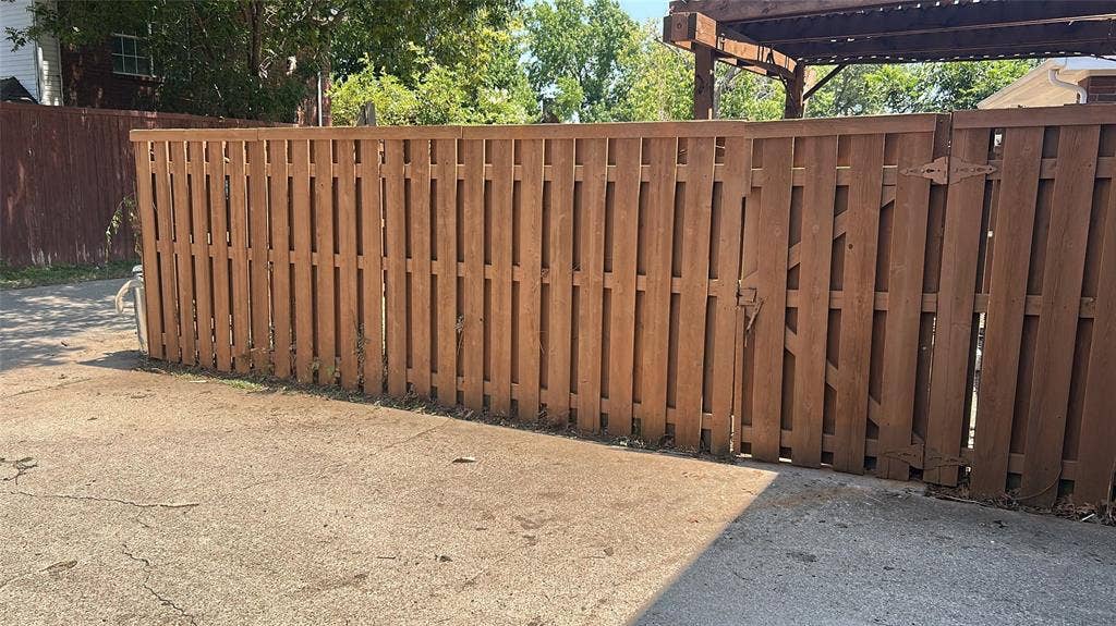 550 Village Green Drive, Coppell, TX 75019 Wooden privacy fence with a double gate and dark brown hardware