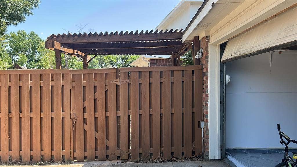 550 Village Green Drive, Coppell, TX 75019 Wood privacy fence with gate, wood pergola, brick exterior, and attached garage