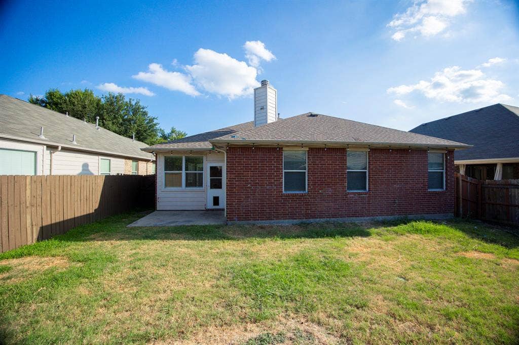 5728 Calloway Drive, McKinney, TX 75070 Brick exterior with a screened-in porch, concrete patio, and private wood fencing