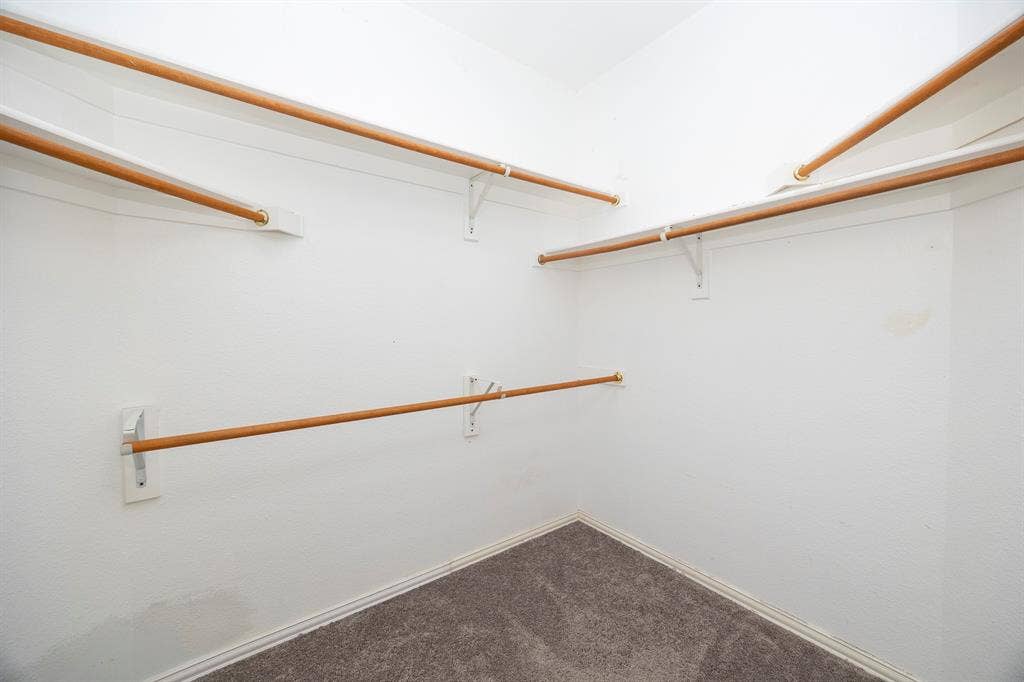 5728 Calloway Drive, McKinney, TX 75070 Walk-in closet featuring white walls, multi-level hanging rods, and gray carpet flooring