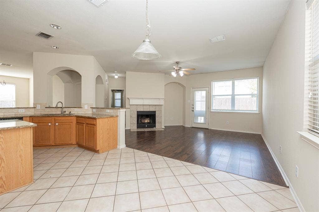 5728 Calloway Drive, McKinney, TX 75070 Kitchen featuring wood cabinetry, granite countertops, and tile flooring