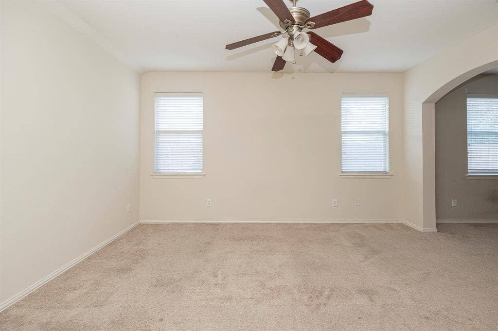 5728 Calloway Drive, McKinney, TX 75070 Neutral toned walls, light carpeting, two windows with blinds, and a ceiling fan with light fixture