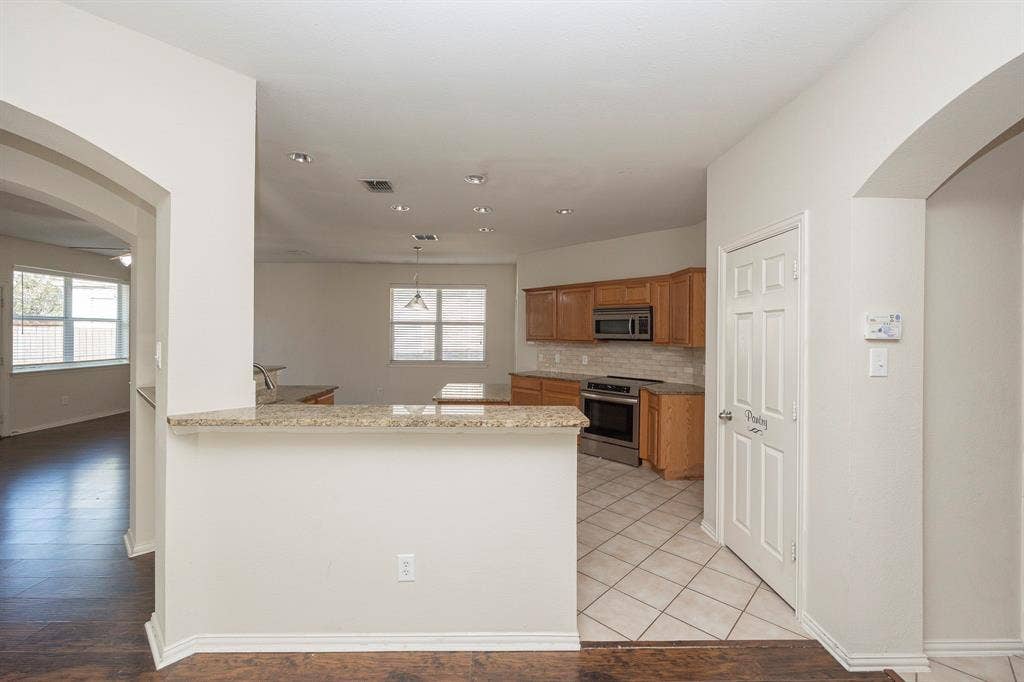 5728 Calloway Drive, McKinney, TX 75070 Kitchen with tile flooring, wood cabinetry, stainless steel oven, and a built-in microwave