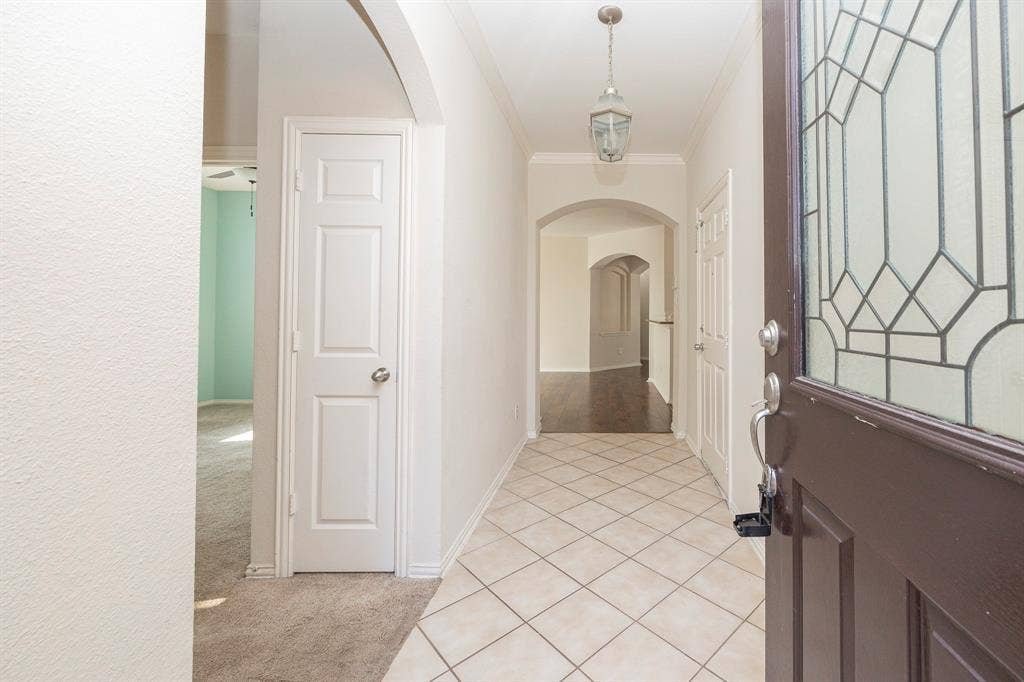 5728 Calloway Drive, McKinney, TX 75070 Entryway featuring diamond-patterned tile flooring, an arched doorway, and a decorative pendant light fixture