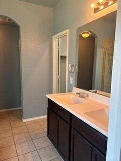 1316 Shelley Drive, Burleson, TX 76028 Dual vanity with integrated sinks, dark wood-finish cabinetry, and a large mirror