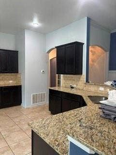 1316 Shelley Drive, Burleson, TX 76028 Tile flooring, dark wood-finish cabinetry, speckled countertops, and a tile backsplash