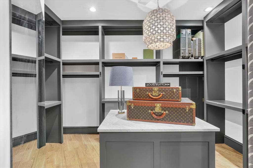 5 SAVANNAH Circle, Frisco, TX 75034 Custom-fitted primary closet offers extensive storage with a center island and thoughtfully designed built-ins.