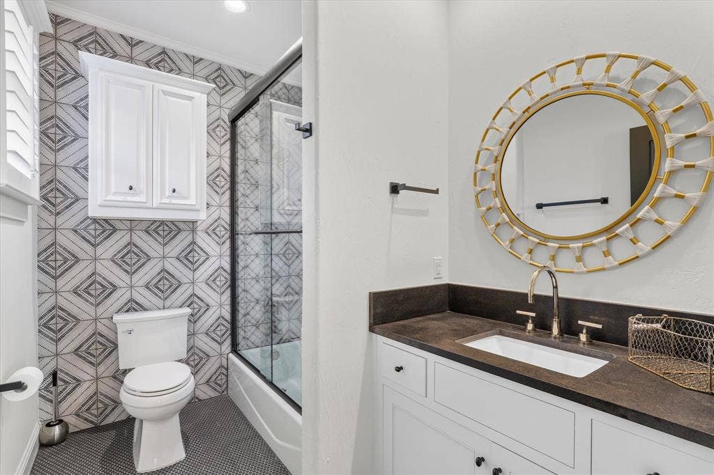 5 SAVANNAH Circle, Frisco, TX 75034 Stylish secondary bath with graphic tile, custom vanity and glass-enclosed tub/shower.