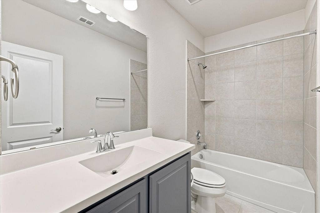 Vanity with a solid surface countertop, undermount sink, and chrome fixtures