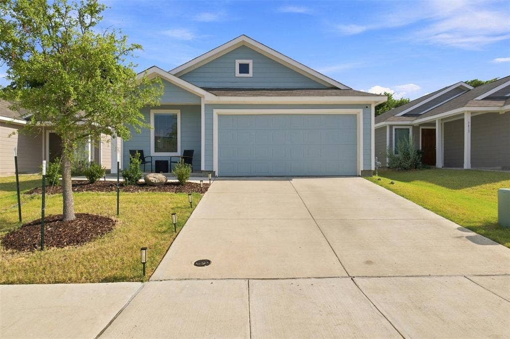 3409 Flicker Lane, McKinney, TX 75071 Single-story residence featuring light blue siding, an attached two-car garage, and a concrete driveway