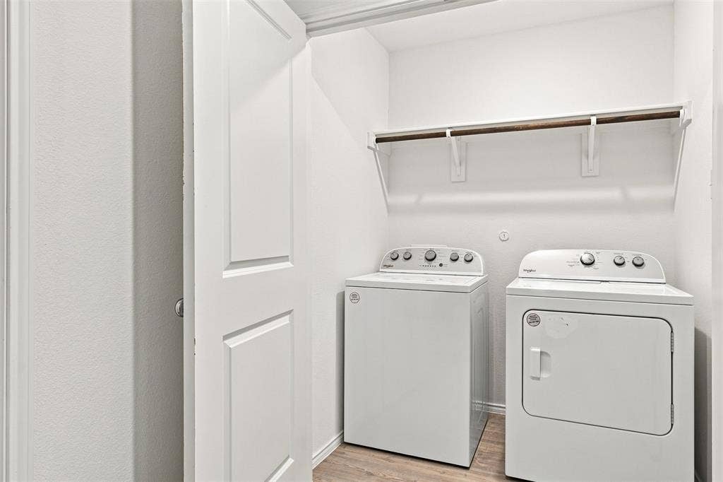 3409 Flicker Lane, McKinney, TX 75071 Dedicated laundry closet featuring a built-in shelf and hanging rod, with wood-finish flooring