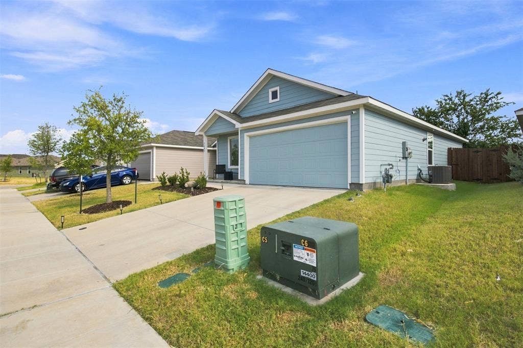 3409 Flicker Lane, McKinney, TX 75071 Light blue siding with white trim, two-car garage, concrete driveway, and a manicured lawn