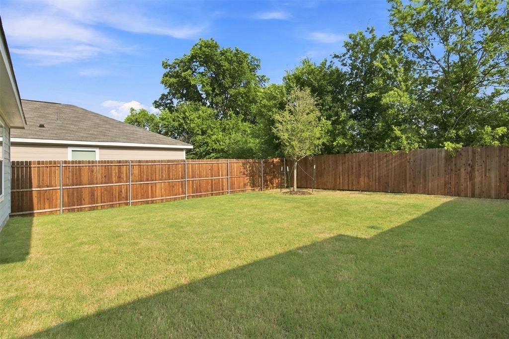 3409 Flicker Lane, McKinney, TX 75071 Expansive green lawn with a full privacy fence